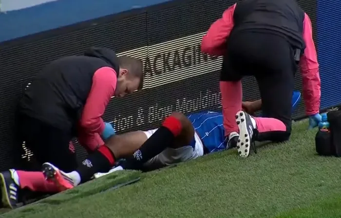 Rangers forması giyen futbolcuya saha kenarında sağlık görevlileri müdahale ediyor.