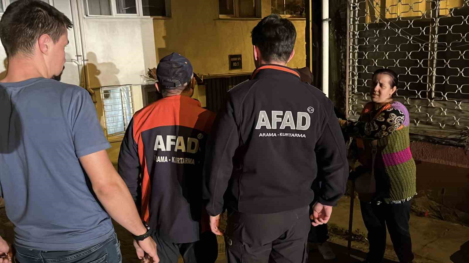 AFAD görevlileri ve vatandaşların apartman girişinde görüldüğü gece görüntüsü.