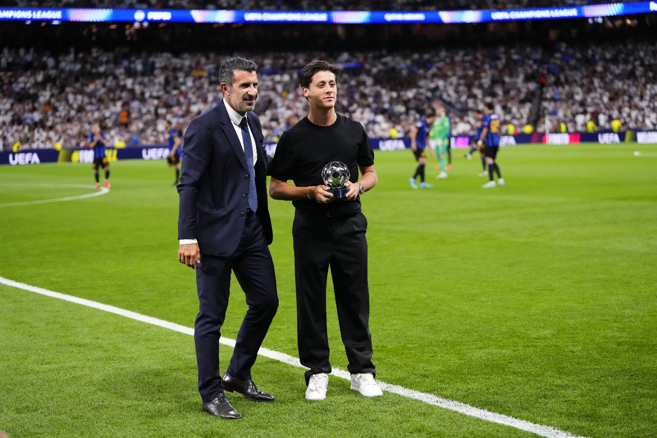 Arda Güler and Luis Figo are seen at the awards ceremony on the pitch before the Champions League match.