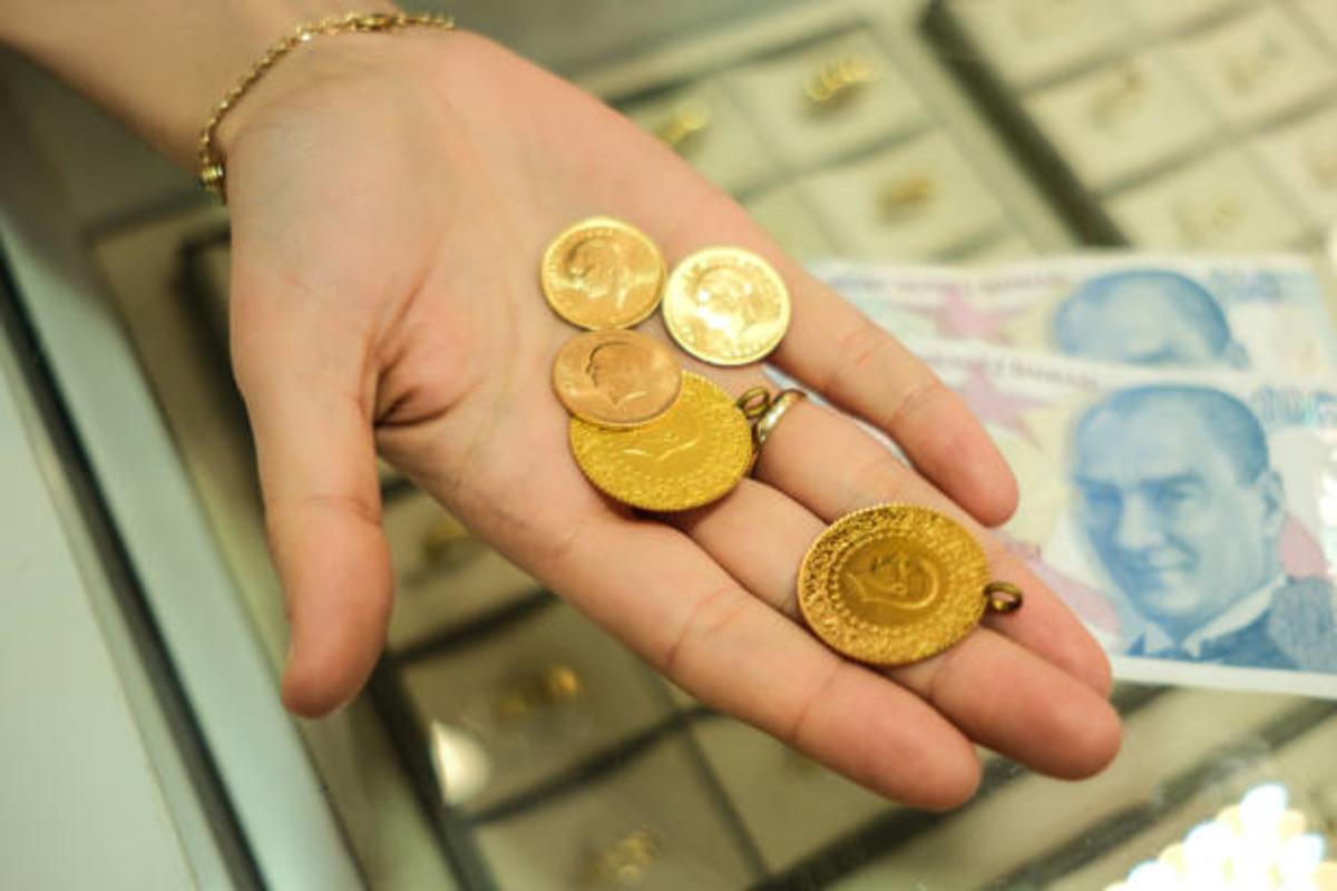 Bir kişinin avucunda altınlar ve arka planda Türk lirası banknotlar.