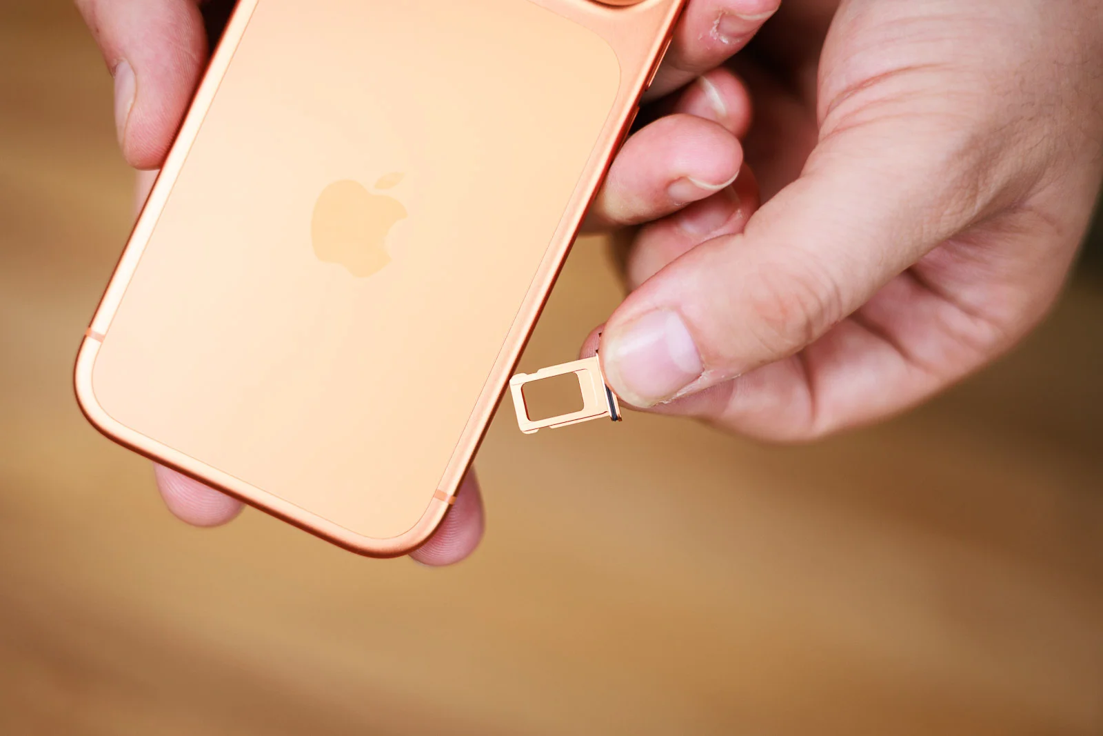 A close-up shot of a SIM card being inserted into an iPhone.