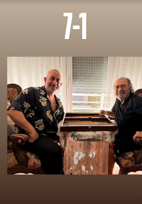 Cem Yılmaz e suo padre Arif Yılmaz sorridono al tavolo da backgammon.