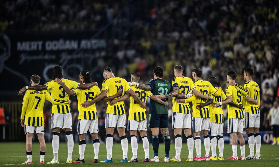 Fenerbahçeli futbolcular maç öncesinde sahada yan yana dizilmiş halde görülüyor.