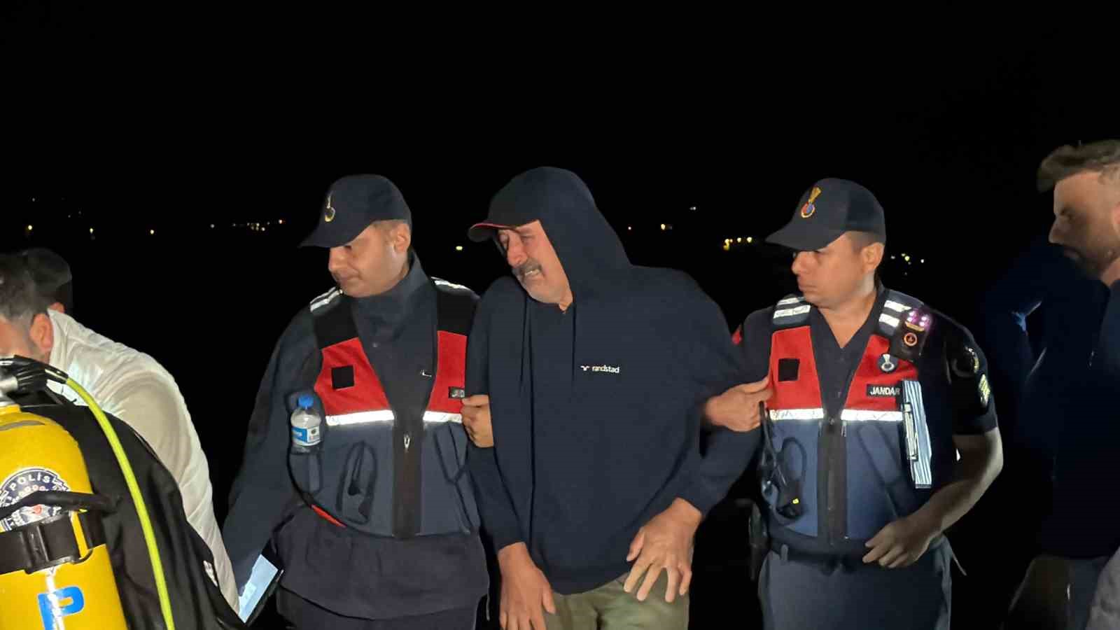 İznik Gölü kıyısında jandarma ekipleri arasında üzüntü yaşayan bir kişi görülüyor.