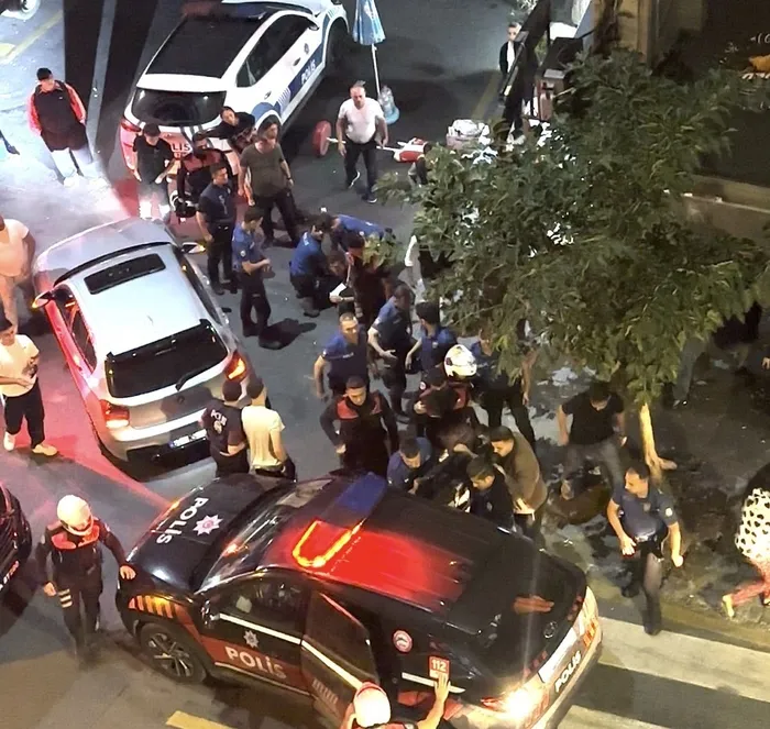Gece saatlerinde bir sokakta polis araçları ve ekiplerin bulunduğu olay yeri görüntüsü.
