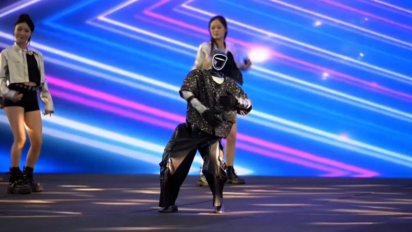 A show featuring a costumed robot dancing on an illuminated stage.