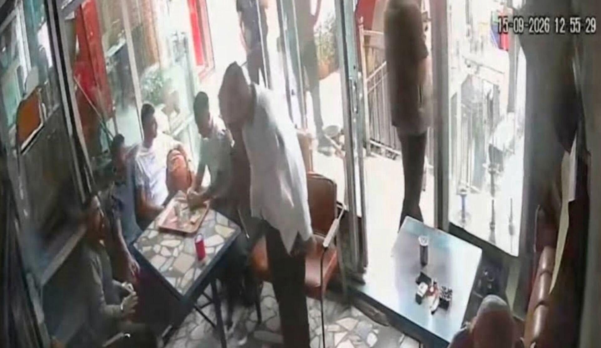 Çay ocağında bulunan kişilerin ve giriş kapısının görüldüğü güvenlik kamerası karesi.