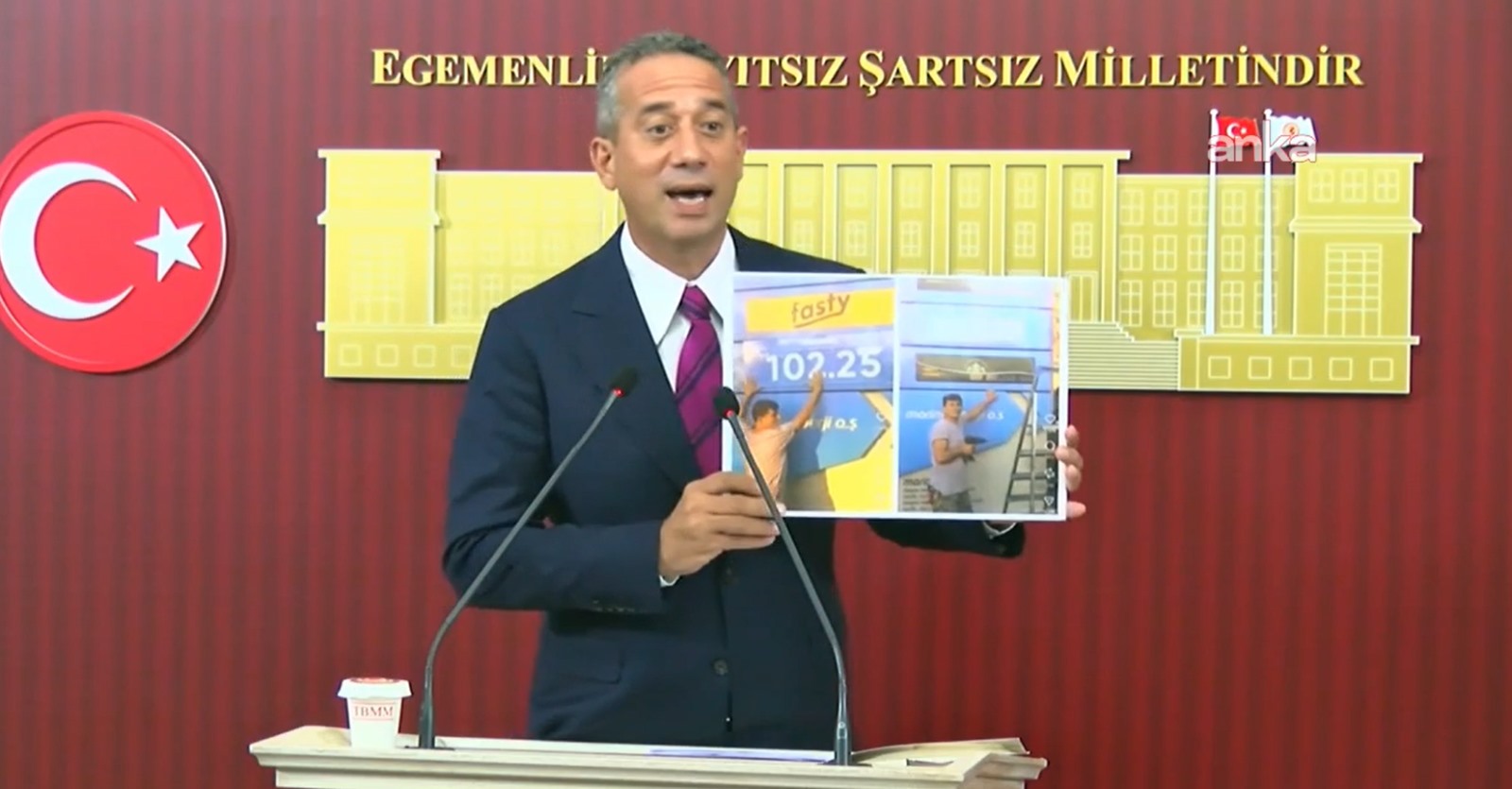 Ali Mahir Başarır holds a visual showing the price of diesel at the TBMM podium.