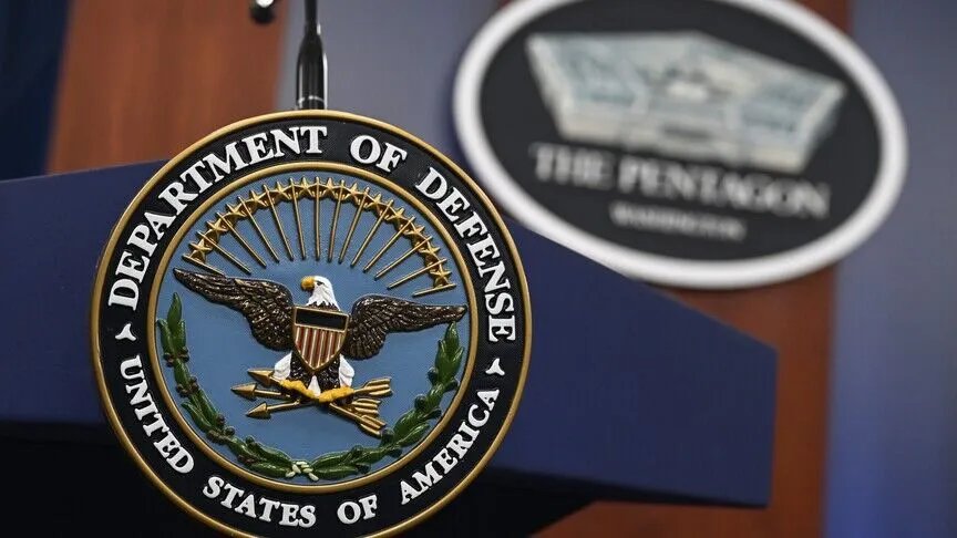 Das Emblem des US-Verteidigungsministeriums und ein Podium mit der Aufschrift Pentagon im Hintergrund.