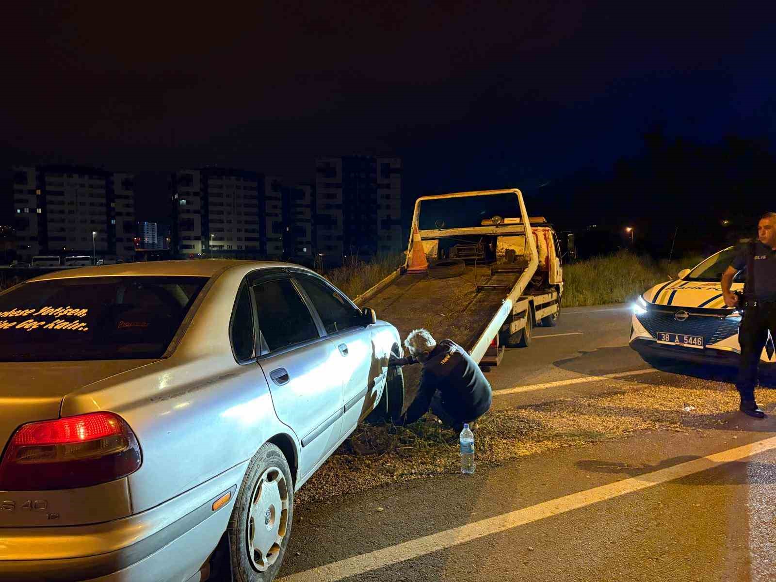 Gece yol kenarında duran otomobilin yanında çekici ve polis aracının bulunduğu denetim alanı.