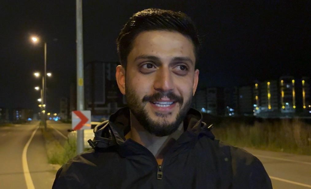 Gece yol kenarında konuşan genç erkek sürücünün yakın plan görüntüsü.