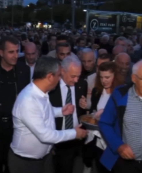 Kalabalık bir yürüyüş sırasında Özgür Özel’e tepsiyle börek uzatıldığı an.