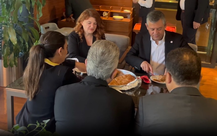 Özgür Özel, Canan Uzer ve beraberindekilerin börekli kahvaltı sofrasında oturduğu görüntü.