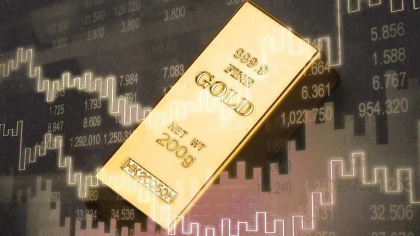 Finansal grafiklerin önünde altın külçesi görseli.