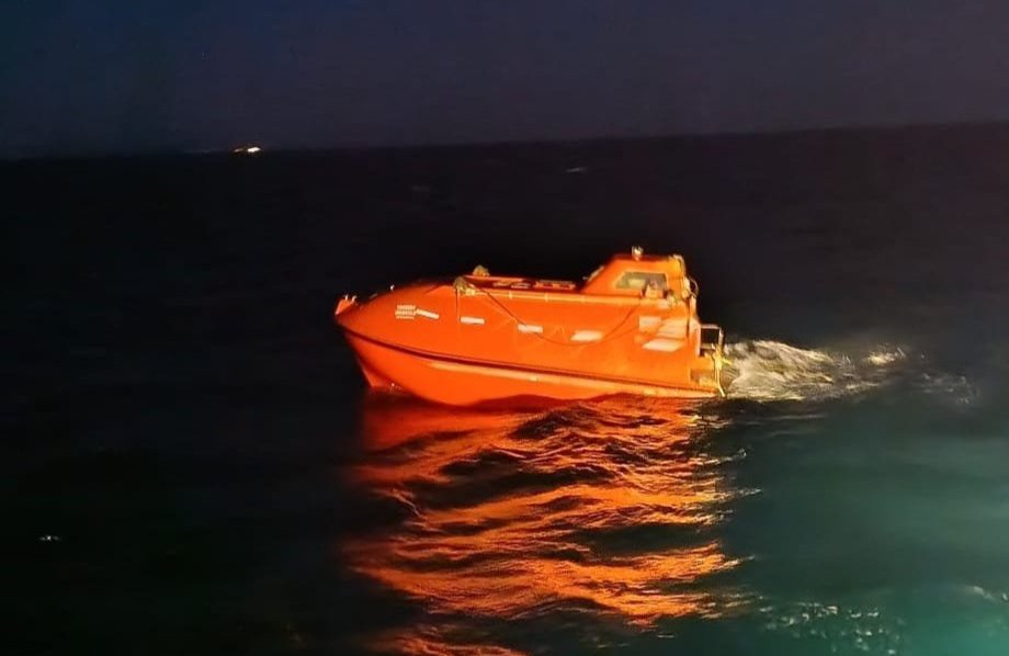 An orange lifeboat seen on the water in the Sea of Marmara at night.
