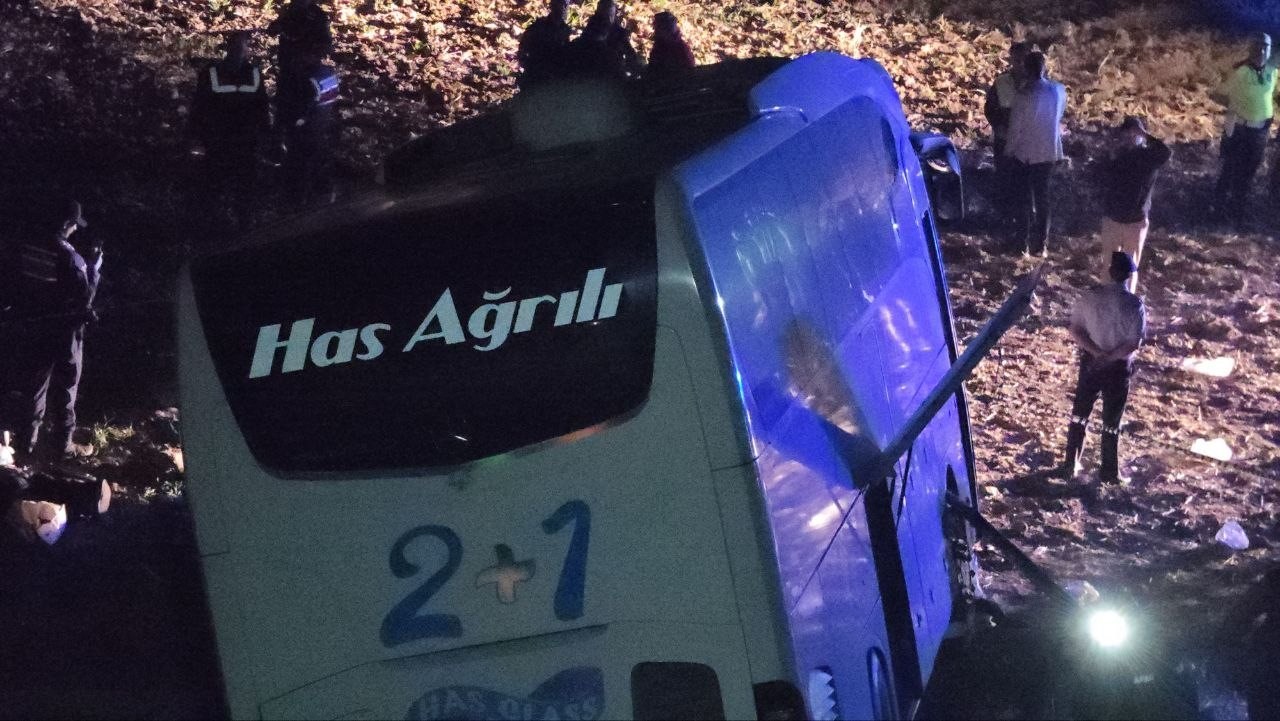 Şarampole devrilen yolcu otobüsünün gece çekilmiş yakın görüntüsü.