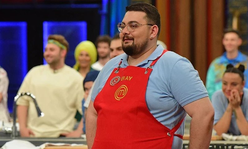 Ein Foto von Eray Aksungur mit der roten Schürze bei MasterChef Türkiye.