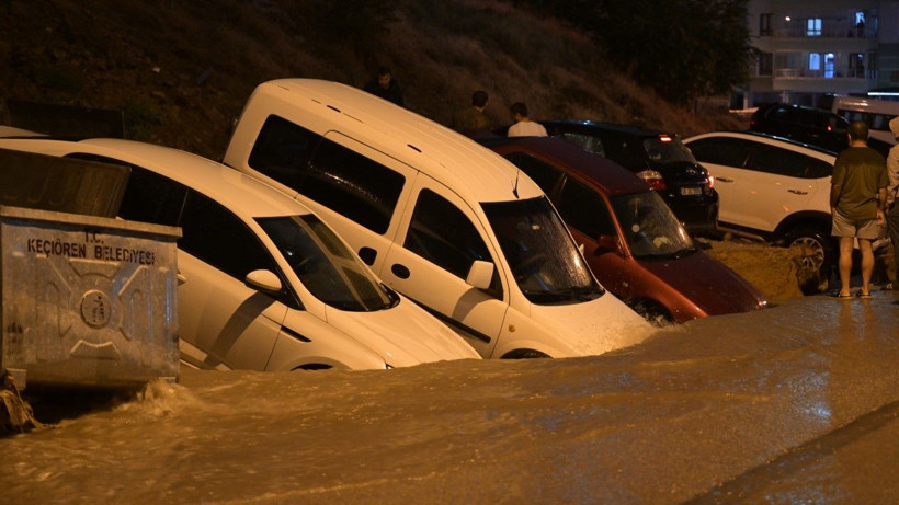 Yol kenarında çamura saplanmış çok sayıda araç görülüyor.