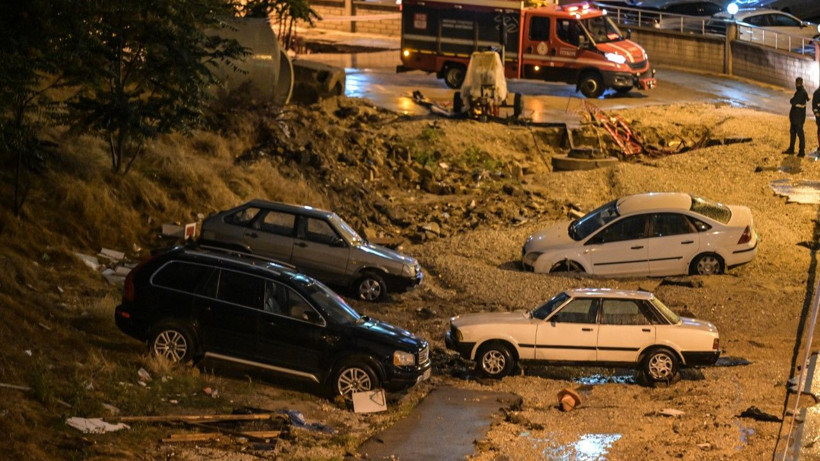Çöken yol ve araçların bulunduğu alanda itfaiye aracı uzaktan görülüyor.