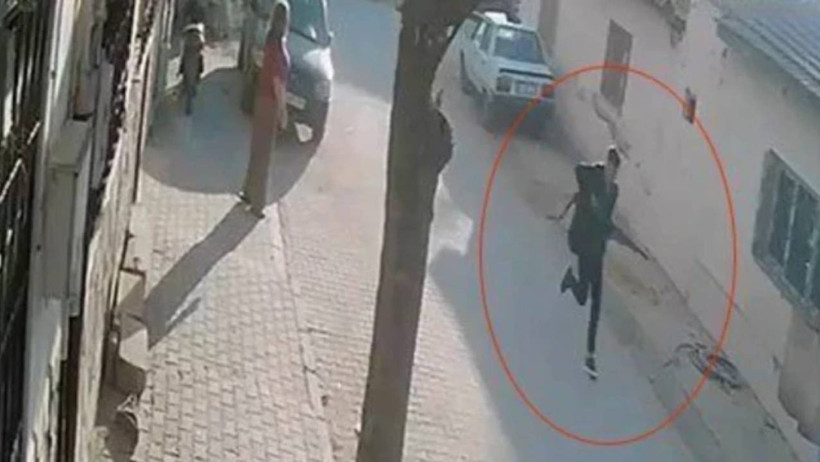 Manisa’nın Turgutlu ilçesindeki saldırıya ilişkin güvenlik kamerası görüntüsünde sokakta ilerleyen silahlı bir kişi görülüyor.