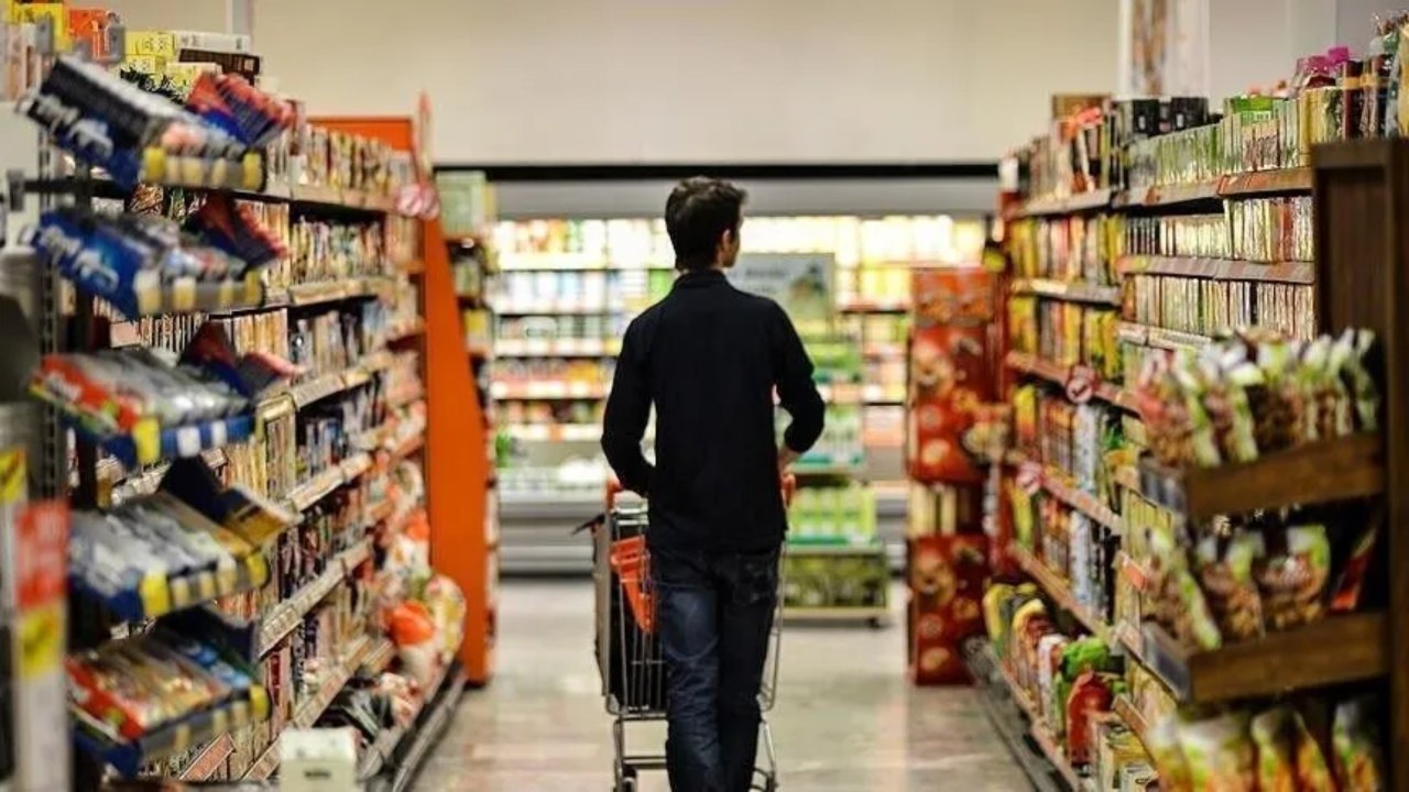 Market rafları arasında alışveriş yapan bir kişi.