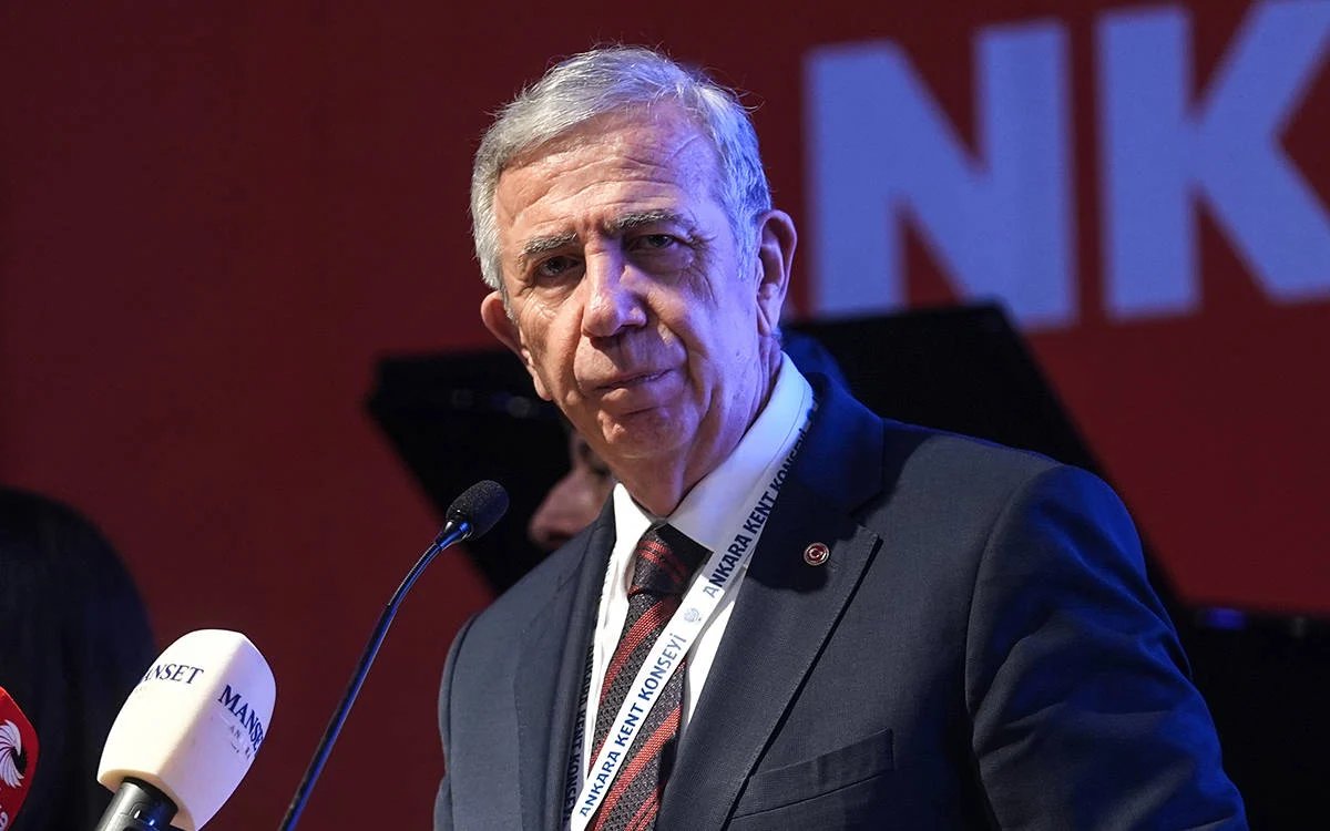 Mansur Yavaş bir etkinlikte mikrofonların önünde konuşurken görülüyor.