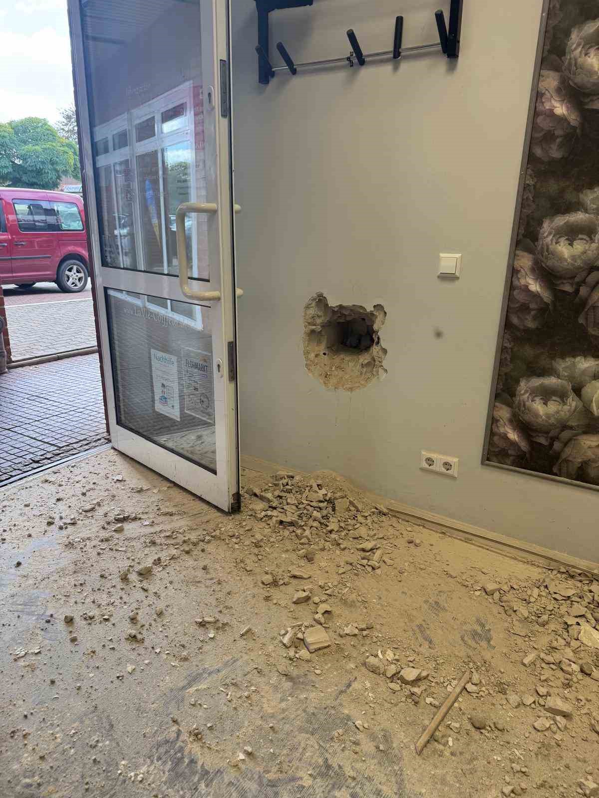 Kuaför salonu girişine yakın bir duvarda açılmış delik ve yere dökülen molozlar.