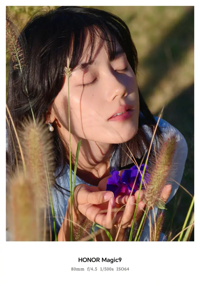 Sample photo taken in portrait style among flowers and grass, shared with the Honor Magic 9 tag.