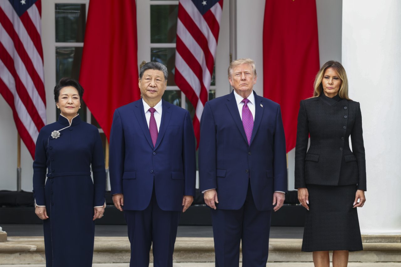 Donald Trump and Xi Jinping are seen standing in front of US and Chinese flags in front of the White House.