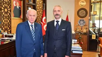A photo of two people posing side by side in an office.