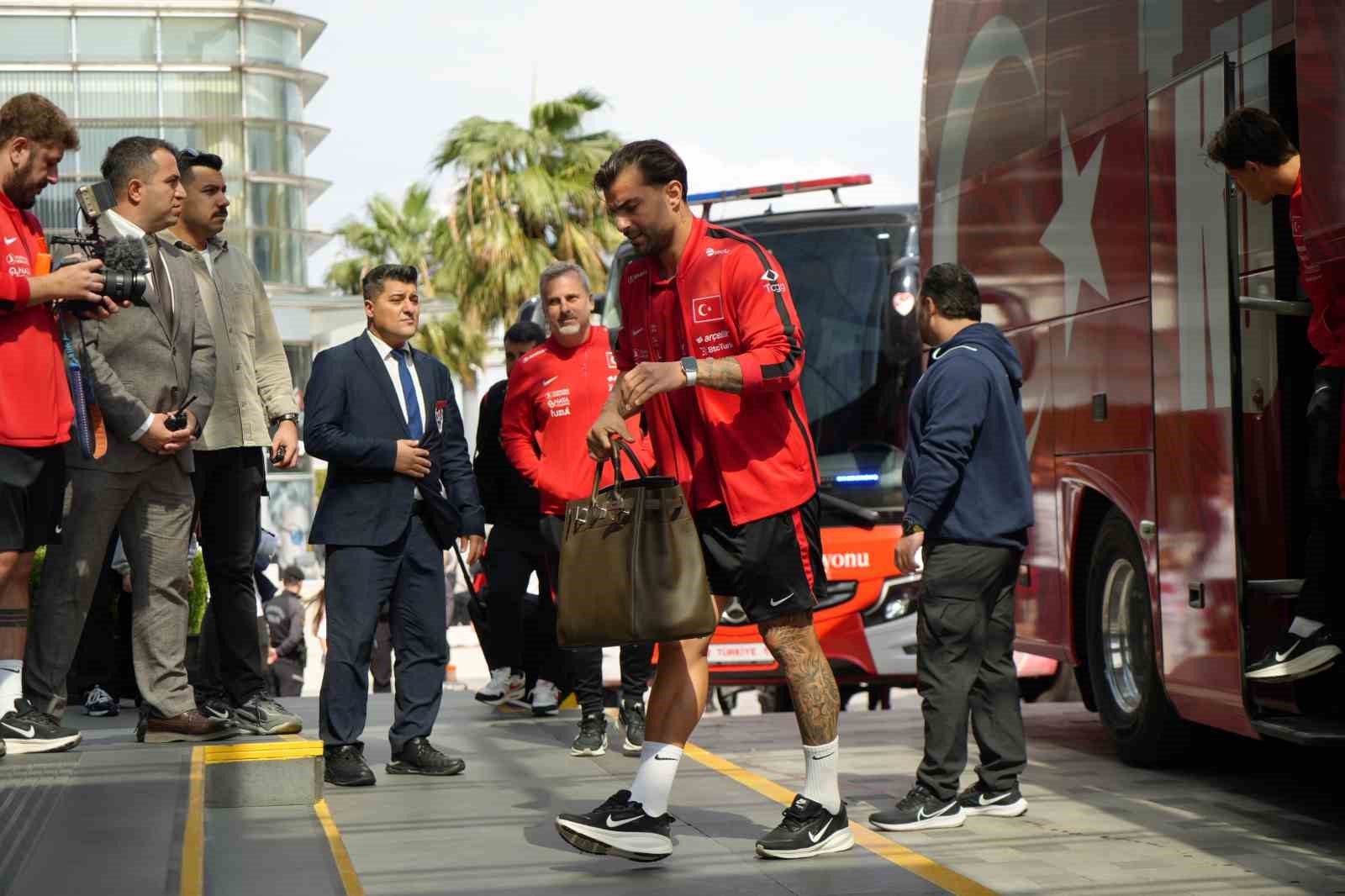 Kırmızı antrenman üstleri giyen milli futbolcuların otel girişinde yürüdüğü kare.