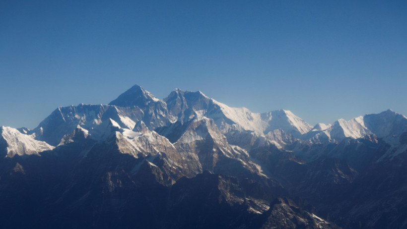 Snow-covered Himalayan mountains under a blue sky.