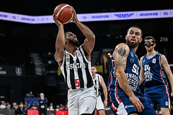 Un jugador del Beşiktaş se dirige a la canasta mientras los jugadores del Anadolu Efes se posicionan en defensa.