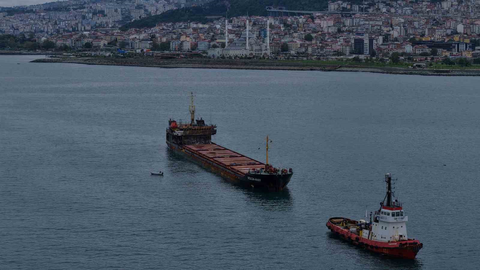 Trabzon şehir silueti önünde VOLGA-4007 yük gemisi ve yakınındaki römorkör görülüyor.