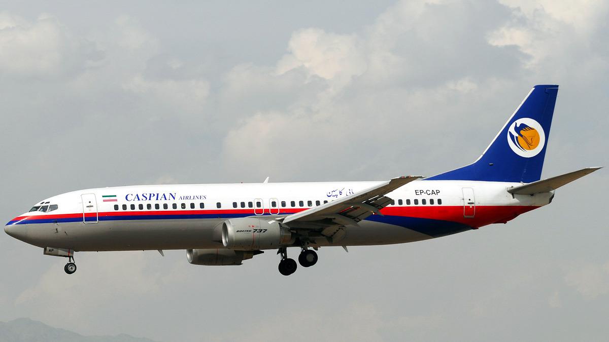 A passenger plane bearing the Caspian Airlines logo is seen in the air.