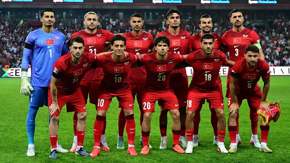 A Milli Futbol Takımı oyuncuları kırmızı formalarıyla sahada takım fotoğrafı için poz veriyor.