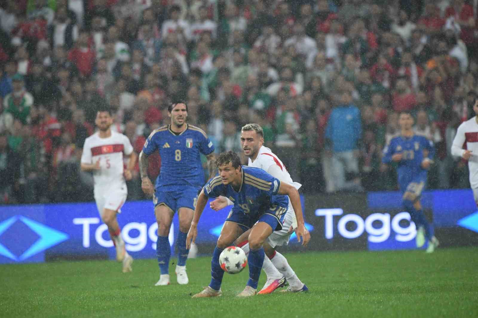 Fußballer im Zweikampf während des Spiels Türkei-Italien im Regen.