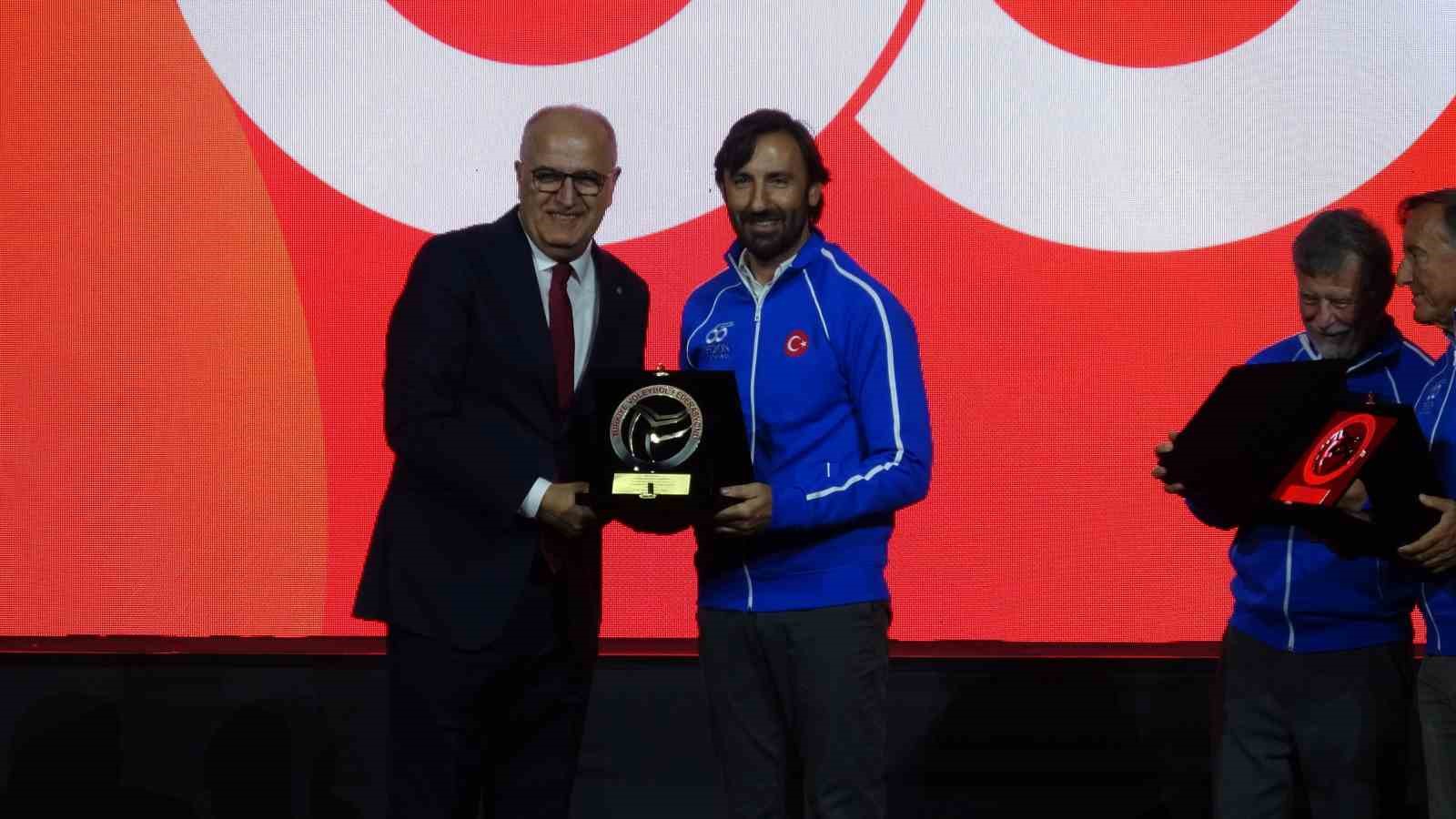 Sahnede Türkiye Voleybol Federasyonu temsilcisi tarafından plaket takdim edilen bir Eczacıbaşı Spor Kulübü yetkilisi.