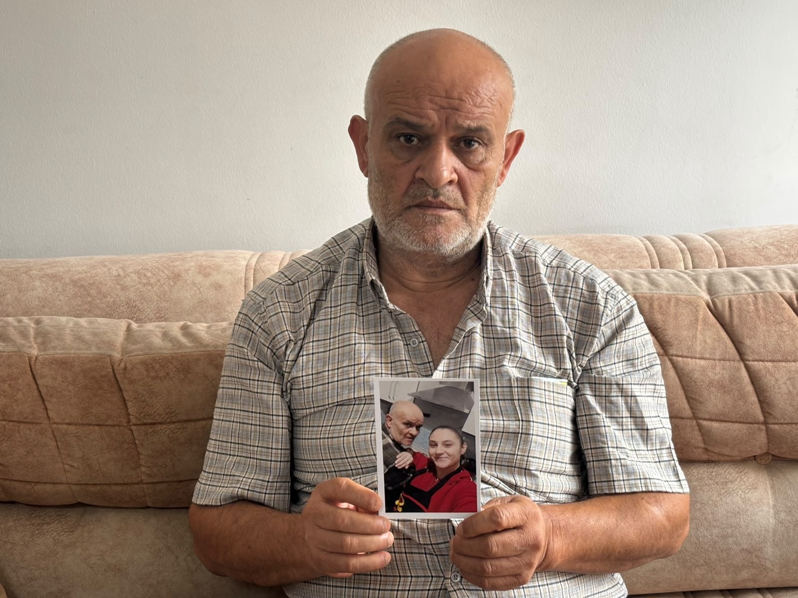Hasan Akgün aparece sosteniendo una fotografía de su hija Buse Akgün Gök.