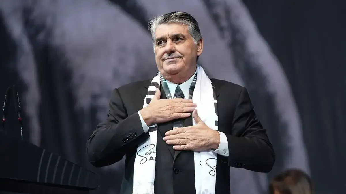 Le président de Beşiktaş, Serdal Adalı, est vu près du pupitre avec une écharpe noire et blanche.