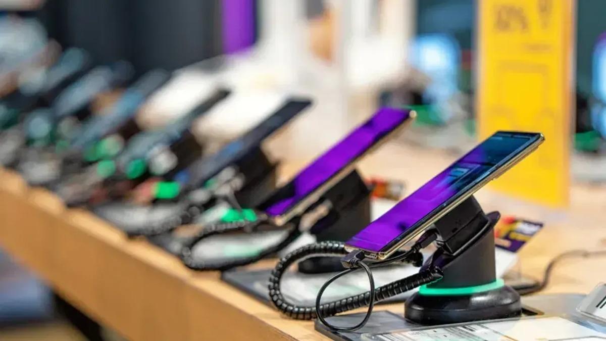 Smartphones exposés en magasin avec des dispositifs de sécurité.