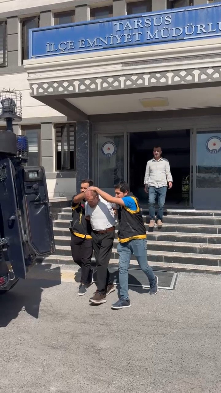 Tarsus İlçe Emniyet Müdürlüğü önünde polis ekiplerince götürülen şüpheli.