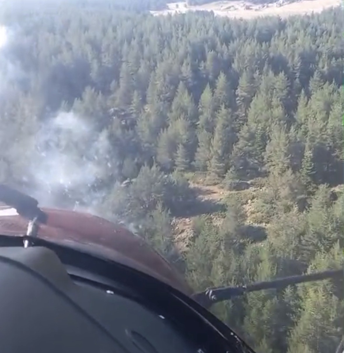 Helikopterden çekilen görüntüde ormanlık alan ve dumanlar görülüyor.
