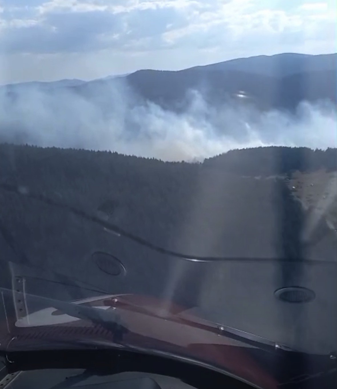 Helikopterden görülen orman yangını dumanları ve dağlık arazi.