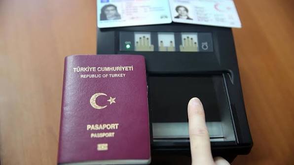 An image featuring a Republic of Turkey passport and an identity control device.