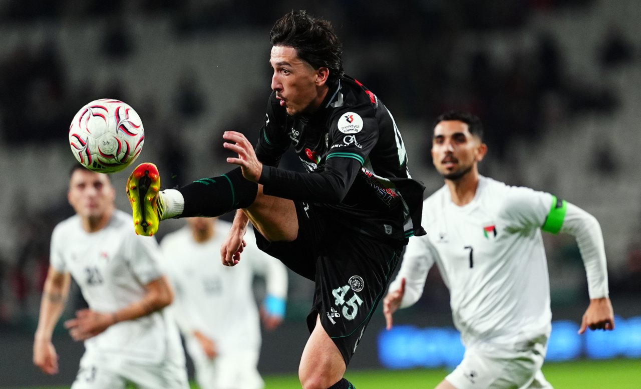 Konyasporlu futbolcunun topa müdahale ettiği, Filistin Milli Takımı oyuncularının takip ettiği maç anı.