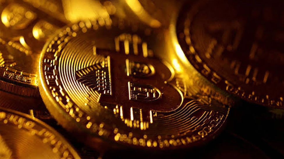 Yakın planda altın tonlarında Bitcoin temsili madeni para görseli.