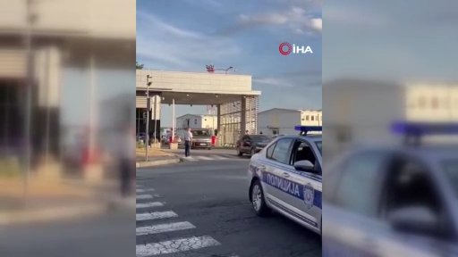 A view of a police vehicle and the funeral convoy in front of a facility entrance in Belgrade.
