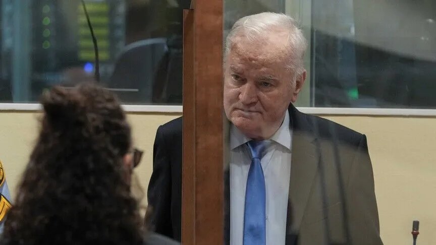 An archive photo of Ratko Mladić seen behind a glass partition in the courtroom.