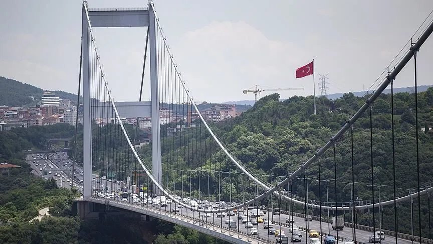 İstanbul'da yoğun trafikli bir asma köprü ve çevresindeki şehir manzarası.